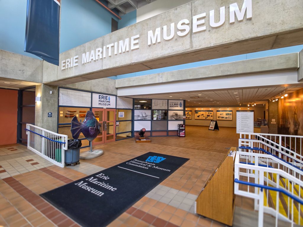 Exterior of the Erie Maritime Museum with flags and ship artifacts in Erie PA.