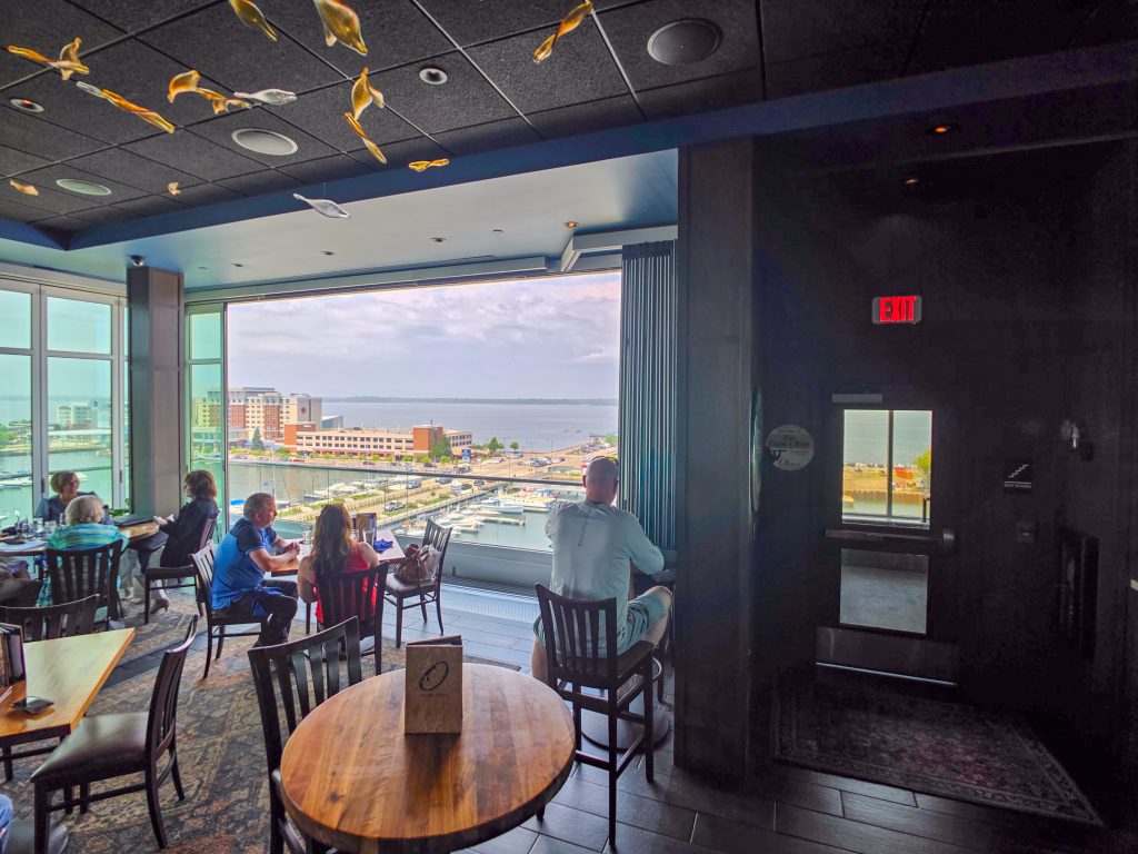 Dinner table at Oliver’s restaurant inside Hampton Inn with a sunset harbor view.
