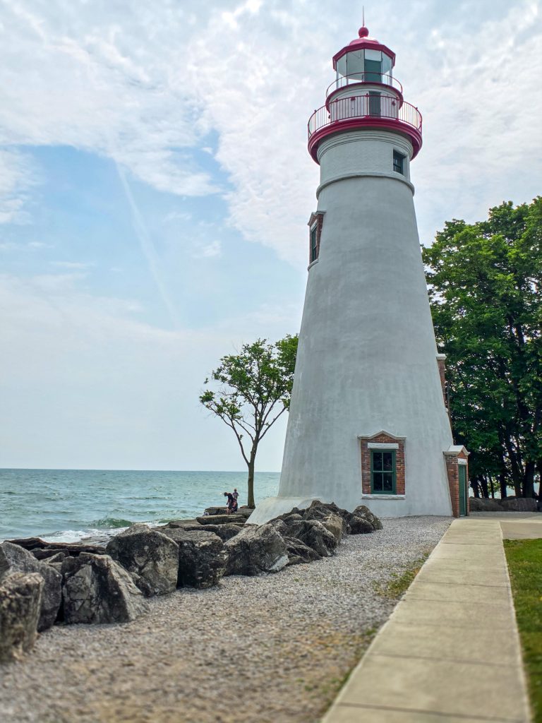 Marblehead Lighthouse with rocky shoreline and blue skies on Lake Erie in Marblehead, Ohio.