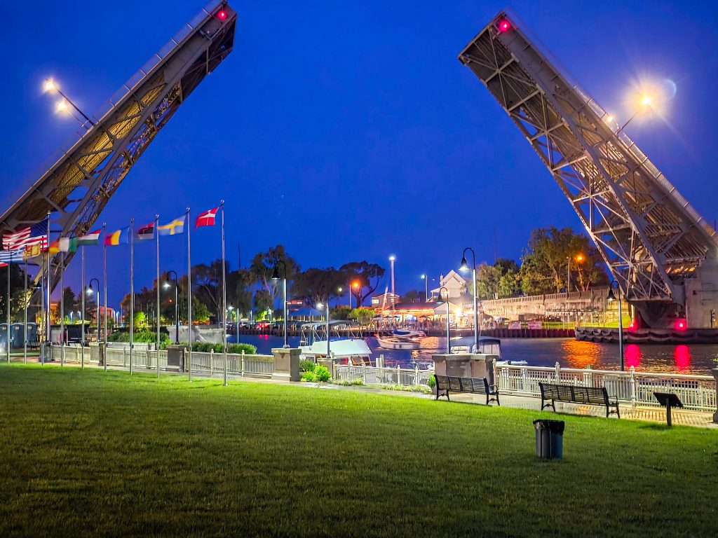 Raised Lorain bascule bridge over the Black River with sunset reflections
